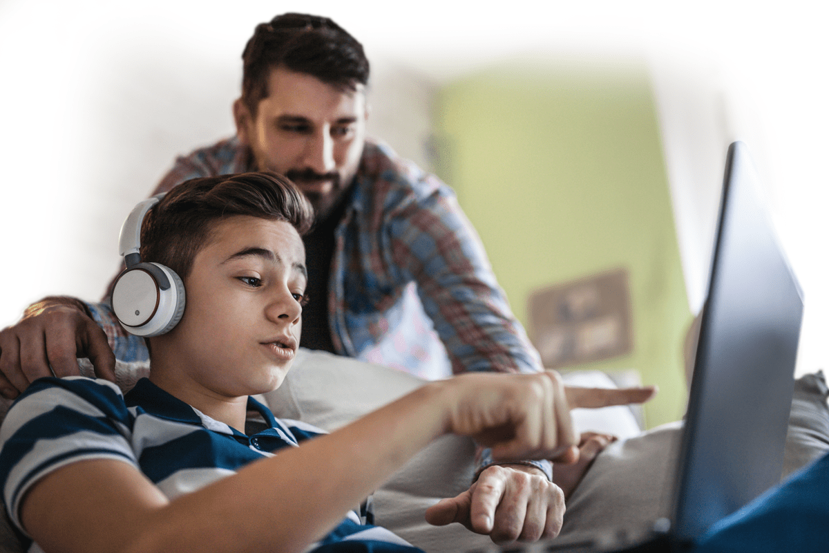 Boy and his dad working on a laptop. 