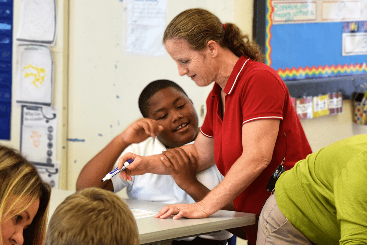 special education teacher assisting one of her students with math