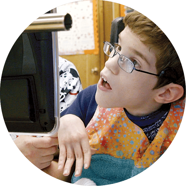 Student with a physical disability getting assistance from a teacher in class