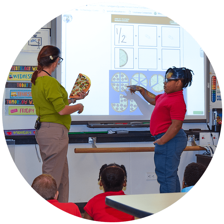 Teacher and student discussing fractions using images of pizzas on a whiteboard